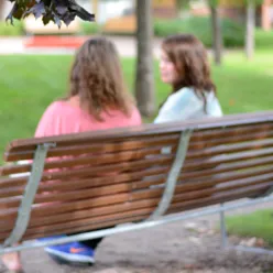 To kvinner i samtale på en benk